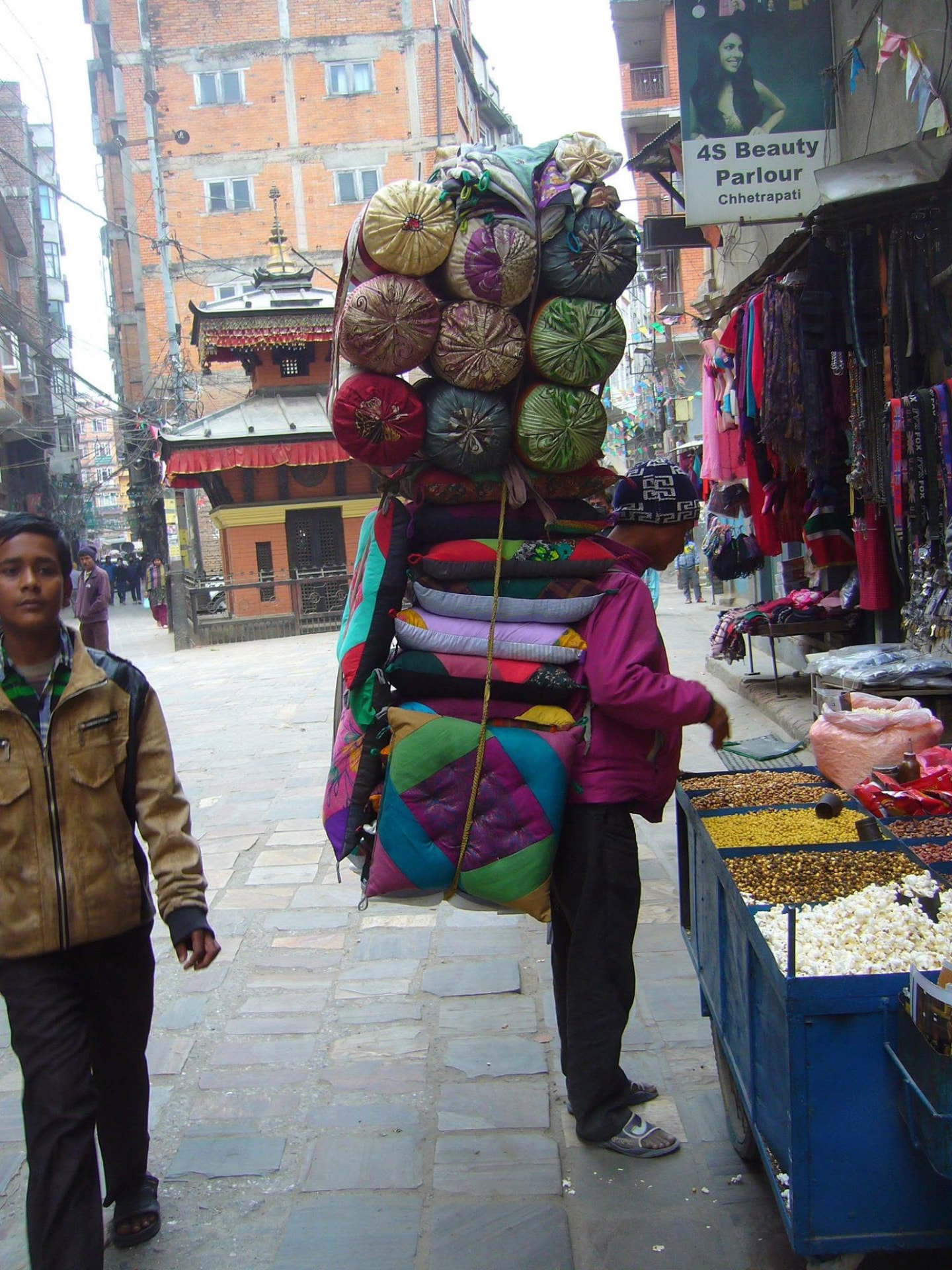 Porteur de coussins traditionnels au marché de Chhetrapati, Katmandou — vie quotidienne népalaise